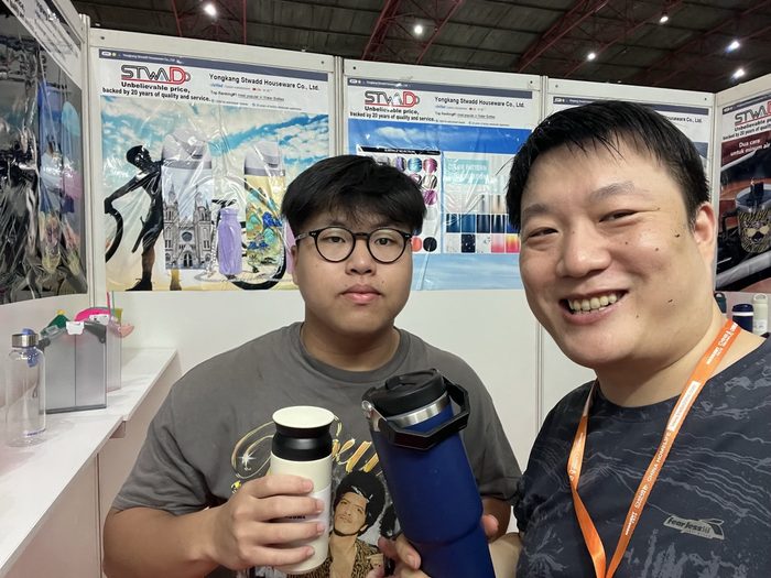 Two Indonesian buyers holding STWADD stainless steel bottles and flasks at HOMELIFE Indonesia